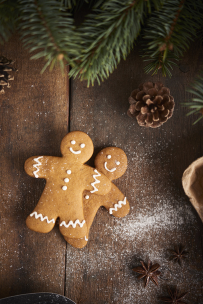Christmas background. Christmas preparation, gingerbread man over wooden background - Photo, Image