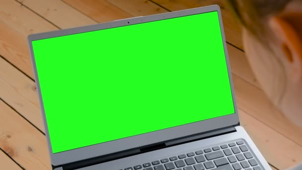 Vrouw op zoek naar laptop met lege groene display - Video