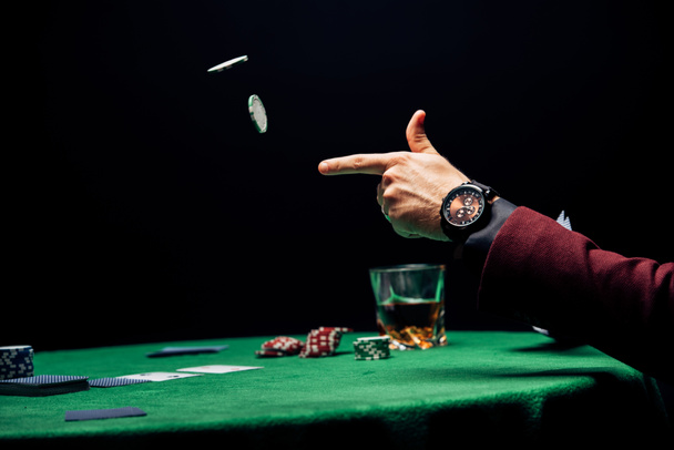 cropped view man throwing in air poker chips isolated on black  - Photo, Image
