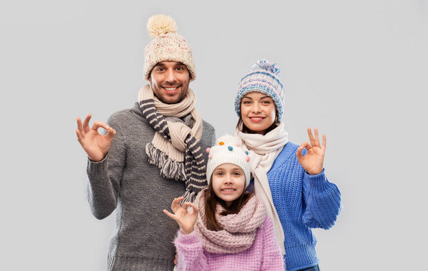 happy family in winter clothes showing ok gesture - Foto, imagen