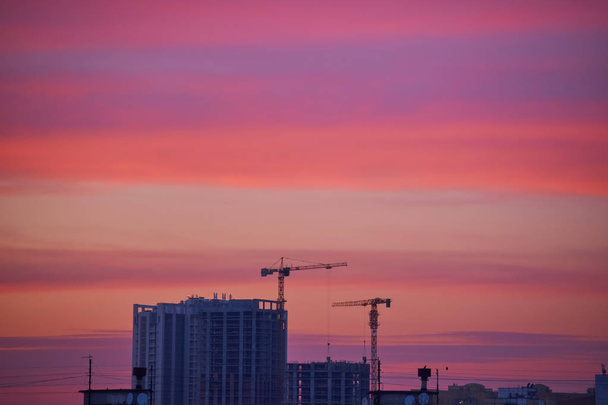 grues sur un chantier de construction au coucher du soleil
 - Photo, image