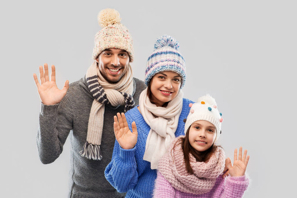 happy family in winter clothes waving hands - Foto, imagen