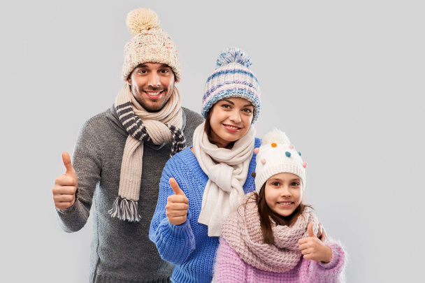 happy family in winter clothes on grey background - Foto, imagen