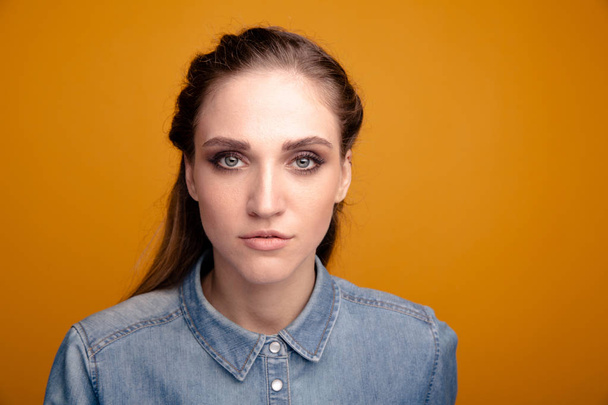 Portrait of woman with pretty face isolated over the yellow background. - 写真・画像