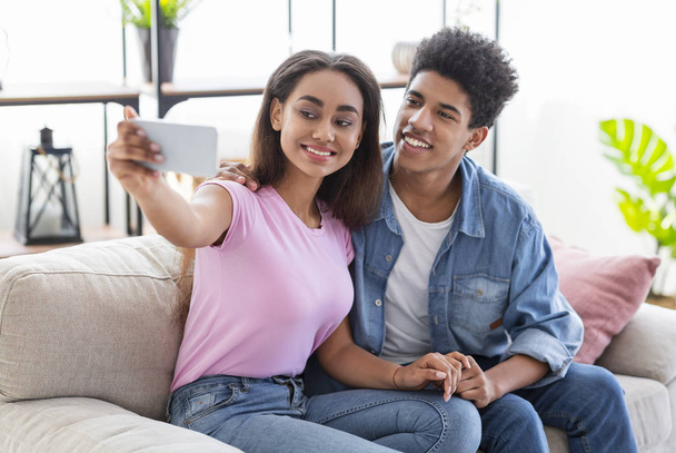 junges afrikanisches Paar macht Selfie mit Smartphone zu Hause - Foto, Bild