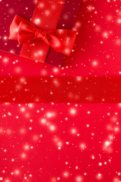 Winter holiday gifts and glowing snow on red background, Christm - Fotó, kép
