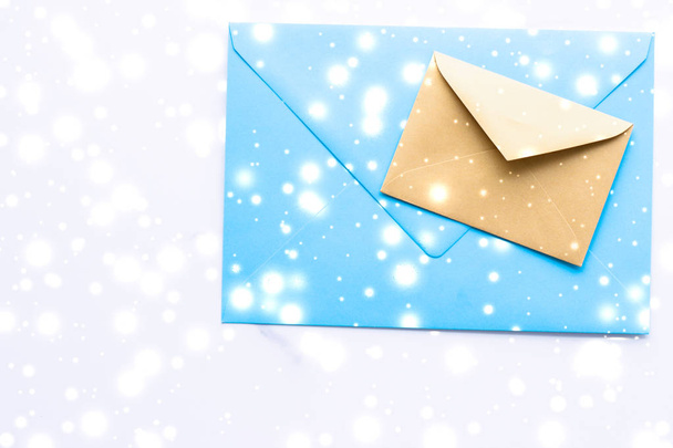 Winter vakantie blanco papieren enveloppen op marmer met glanzende sneeuw f - Foto, afbeelding