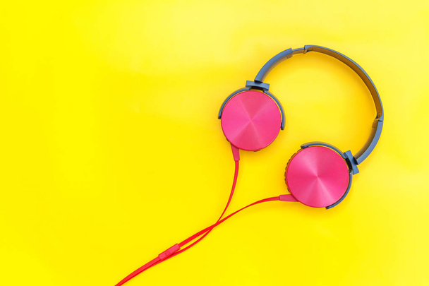 Red headphones with cable isolated on yellow colorful background - Photo, Image