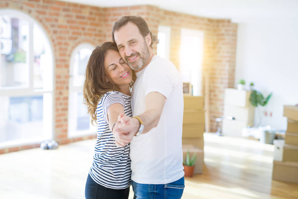 Keski-ikäinen vanhempi pari siirtymässä uuteen taloon, tanssi ja hymyilevä onnellinen rakastunut apartmant
 - Valokuva, kuva
