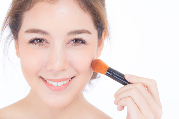 Beauty asian woman applying make up with brush of cheek isolated - 写真・画像