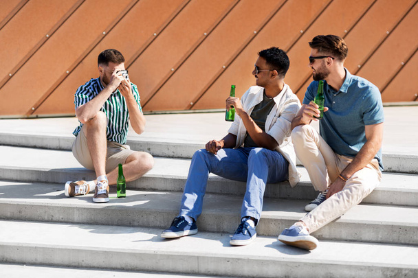 man photographing friends drinking beer on street - Foto, Bild