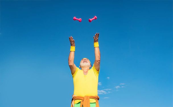 Senior man workout in rehabilitation center. Grandfather sportsman portrait on blue sky backgrounds. Body care and healthcare. Healthy lifestyle concept. - Fotó, kép
