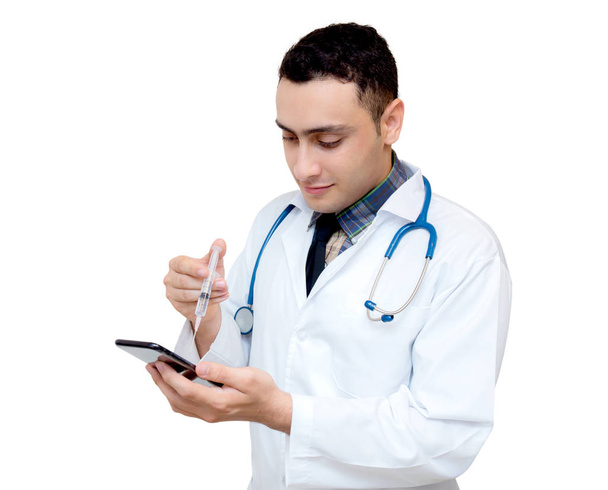 Mano del médico sosteniendo el teléfono inteligente con jeringa; equipo en i
 - Foto, Imagen