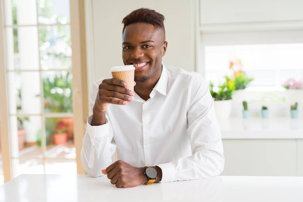 アフリカ系アメリカ人男性が自信を持ってコーヒーを飲んで微笑む - 写真・画像