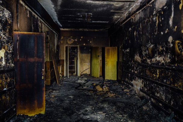 Feuer im Inneren des alten Krankenhauses. Verkohlte Wände und Türen - Foto, Bild