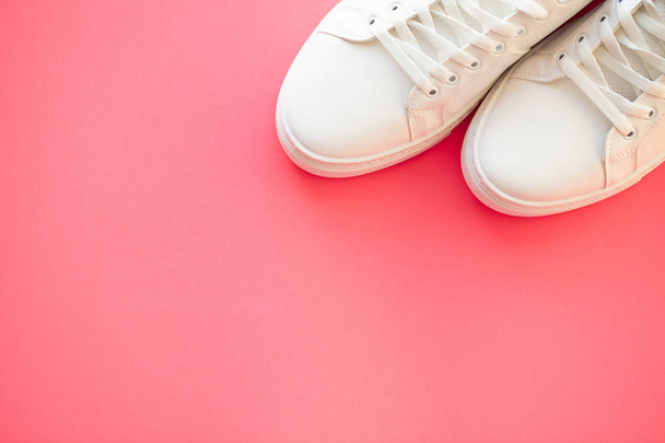 Стильні білі модні кросівки на рожевому фоні
. - Фото, зображення