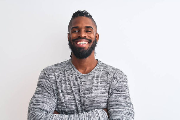 Afrikanisch-amerikanischer Mann mit Zöpfen, grauer Pullover über isoliertem weißem Hintergrund, fröhliches Lächeln mit verschränkten Armen, die in die Kamera schauen. positive Person. - Foto, Bild