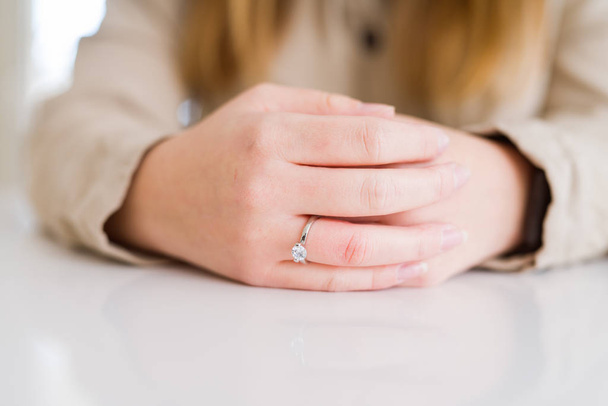 Close up of woman finger showing engagement ring with crossed ha - Foto, Imagen