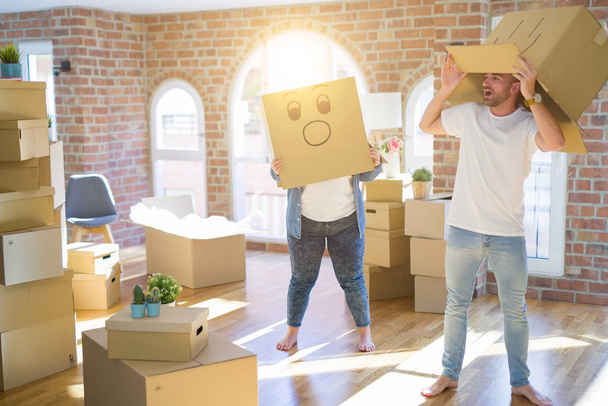 Crazy couple wearing cardboard boxes with funny emoji faces over - Photo, Image