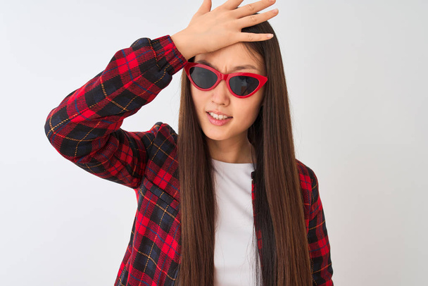 Young chinese woman wearing casual jacket and sunglasses over isolated white background stressed with hand on head, shocked with shame and surprise face, angry and frustrated. Fear and upset for mistake. - Valokuva, kuva