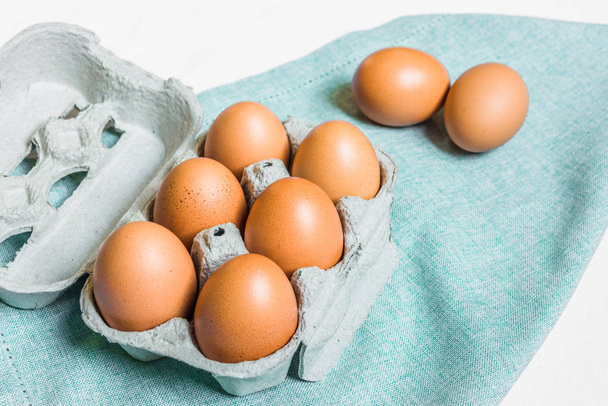 Fresh chicken eggs against white and blue background. - Photo, Image