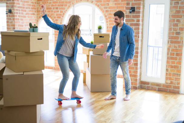 Jeune couple déménageant dans une nouvelle maison, s'amusant à monter un skateboar
 - Photo, image