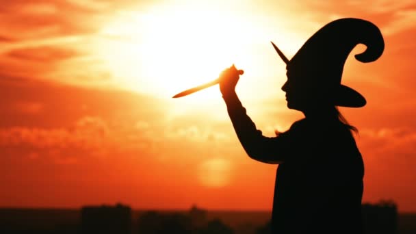 dívka na straně pohled v čarodějnické mašle drží nůž panoráma pomalý pohyb - Záběry, video
