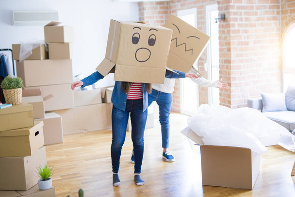 Crazy couple wearing boxes with funny faces over head, having fu - Foto, Bild