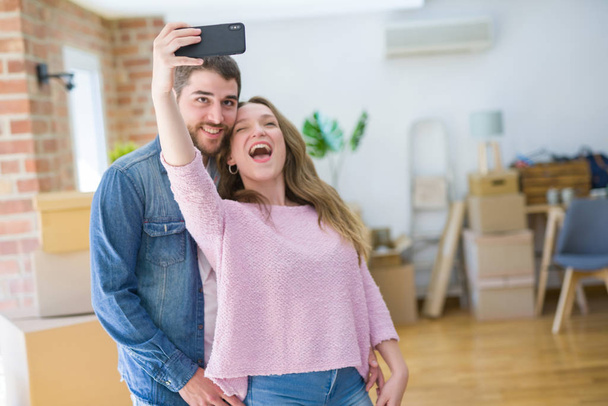 Young beautiful couple taking a selfie photo using smartphone sm - Zdjęcie, obraz