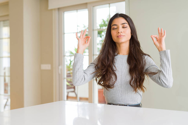 Young beautiful woman at home relax and smiling with eyes closed doing meditation gesture with fingers. Yoga concept. - Φωτογραφία, εικόνα
