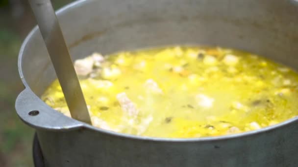 Μεταλλικό κάλρον με βρασμένο πράσινο σούπα και μια σέσουλα που παίρνει λίγο από αυτό σε αργή-mo - Πλάνα, βίντεο