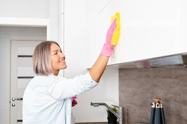 Woman doing Cleaning Kitchen. Washing a kitchen with a yellow Sponge and Detergent. House cleaning - Foto, Imagem