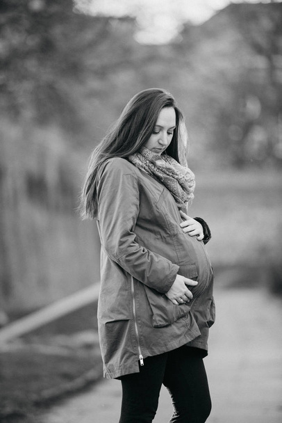 Pregnant woman sticks behind belly - Photo, Image