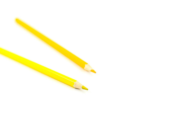 Two yellow pencils on a white background. Selective focus on nearest pencil - Photo, Image