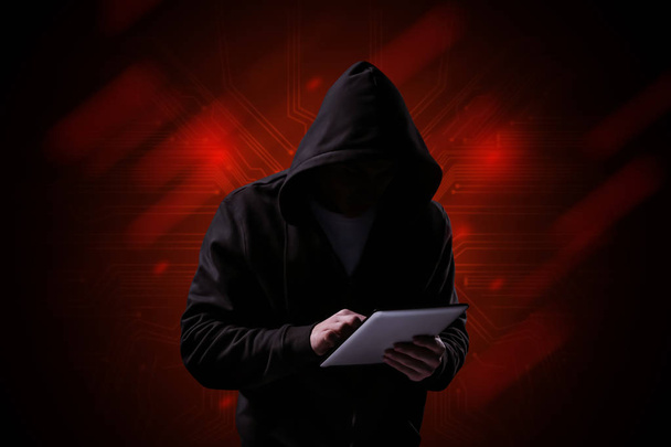 Professional hacker with tablet PC on dark background - Photo, Image
