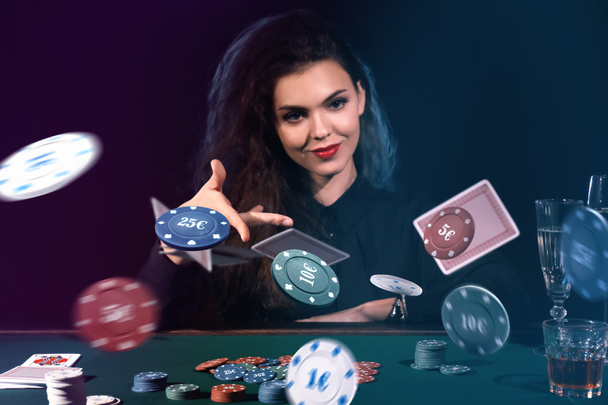 Hermosa jugadora femenina lanzando fichas y cartas a la mesa en el casino
 - Foto, Imagen