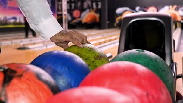 Close up for man hand taking a ball from a rack and throw it to the bowling lane. Media. The player throws a bowling ball that knocks down and rolls. - Footage, Video