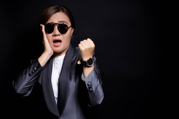 Vrouw dragen van zon glassesin zwart pak controleren haar horloge ze is La - Foto, afbeelding