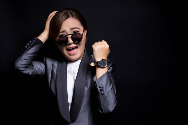 Vrouw dragen van zon glassesin zwart pak controleren haar horloge ze is La - Foto, afbeelding