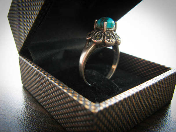 Niebieski turkus pierścień pierścień damski. Zbliżenie srebrny pierścień ozdobiony niebieskim turkusowym kamieniu. Muzułmanie używają go jako Świętego kamienia. Turkusowy pierścień w pudełku z biżuterią - Zdjęcie, obraz