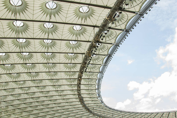 サッカースタジアム内の眺め。サッカー場、空のスタンド、ファンの群衆、空に対する屋根 - 写真・画像