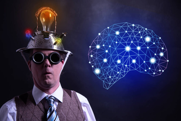 Nerd con sombrero de aluminio de estaño presentando símbolo de inteligencia artificial
 - Foto, imagen