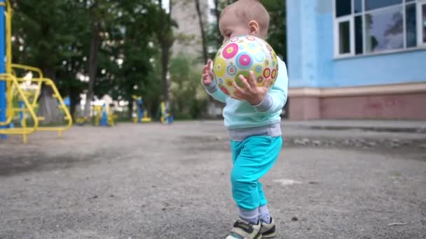 Cesur çocuk bir top ile gidiyor ve slo-mo bir oyun alanı üzerinde bir şey işaret - Video, Çekim