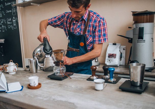 Hamdsome barista faisant du café espresso dans son café - Photo, image
