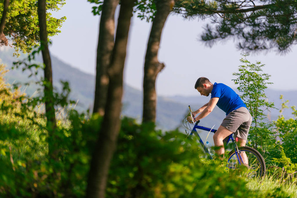 Adventurous mountain biker riding his bike fast through the wood - Photo, Image