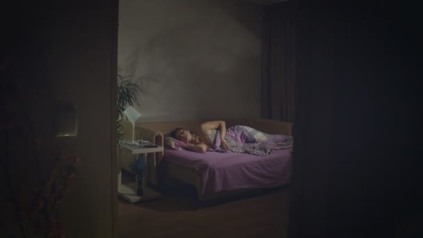 Sleeping woman. Insomnia. 2 Shots.1. A wakes up in the middle of the night, watches time (or reads a message) on her smartphone and tries to fall asleep again.The camera moves from left to right.2. Close-up. The camera moves from right to left. - Footage, Video