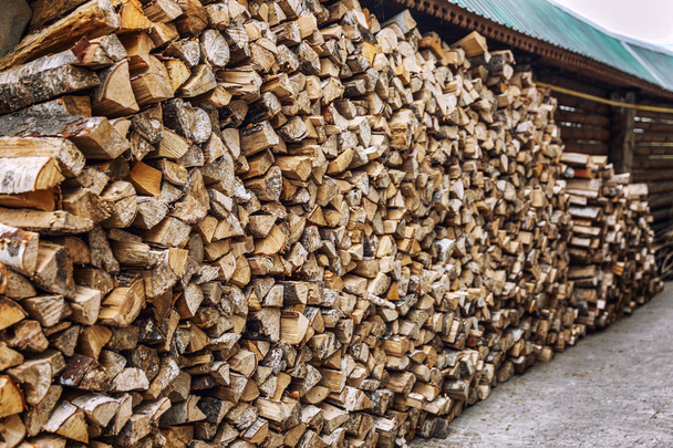 Holzstapel mit ordentlich gestapeltem Brennholz im Hof. - Foto, Bild