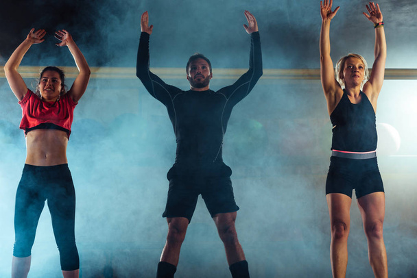 Atraktivní fit lidé trénovat skoky v crossfit tělocvičně - Fotografie, Obrázek