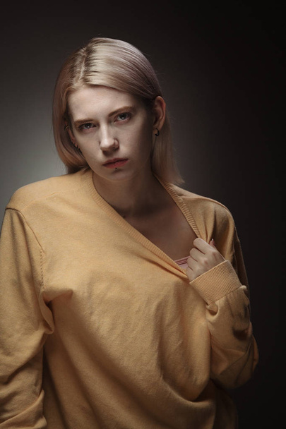 Blonde girl in yellow sweater, studio photography. - Fotoğraf, Görsel