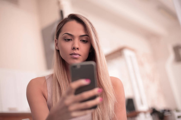 close up. serious young woman reading SMS on her smartphone - Photo, image